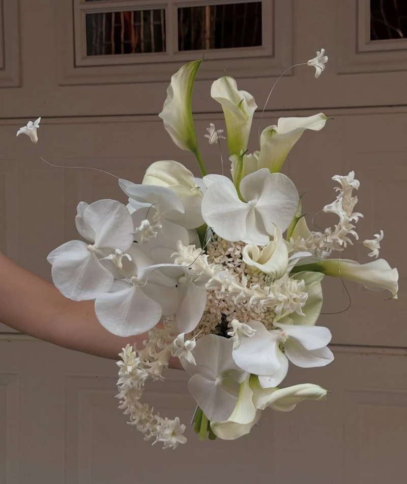 Sculptural white bouquet of calla lilies, orchids and hyacinths