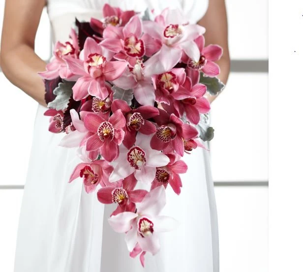 Bride holding a cascading bouquet of vivid pink orchids