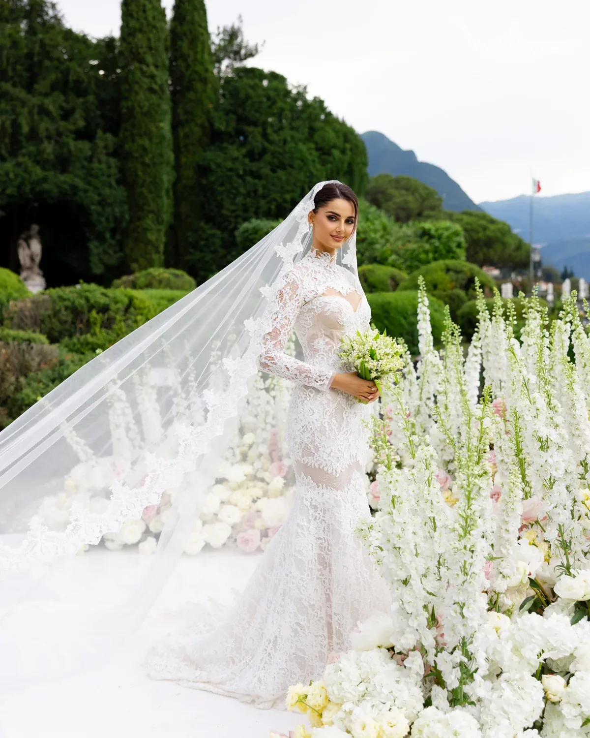 Mahlagha Jaberi in a lace wedding gown and cathedral veil at Lake Como