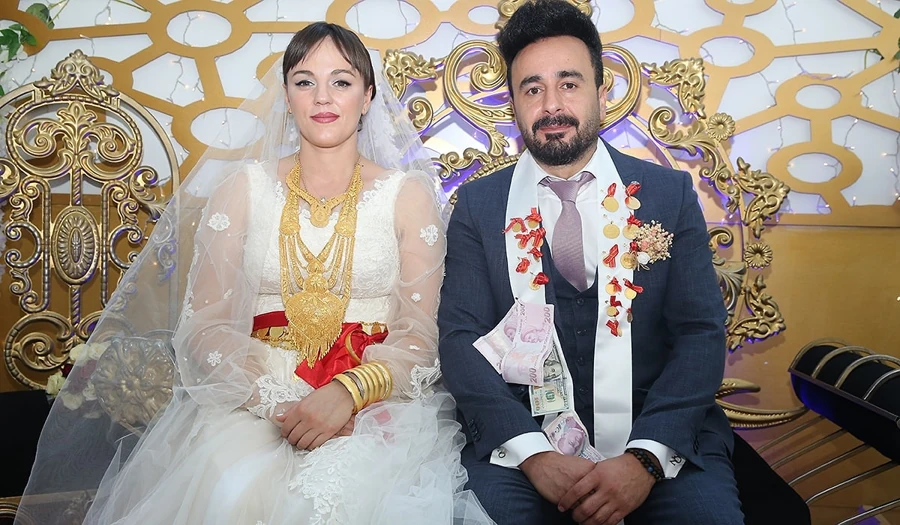 Turkish wedding couple wearing gold jewelry and ceremonial money sashes