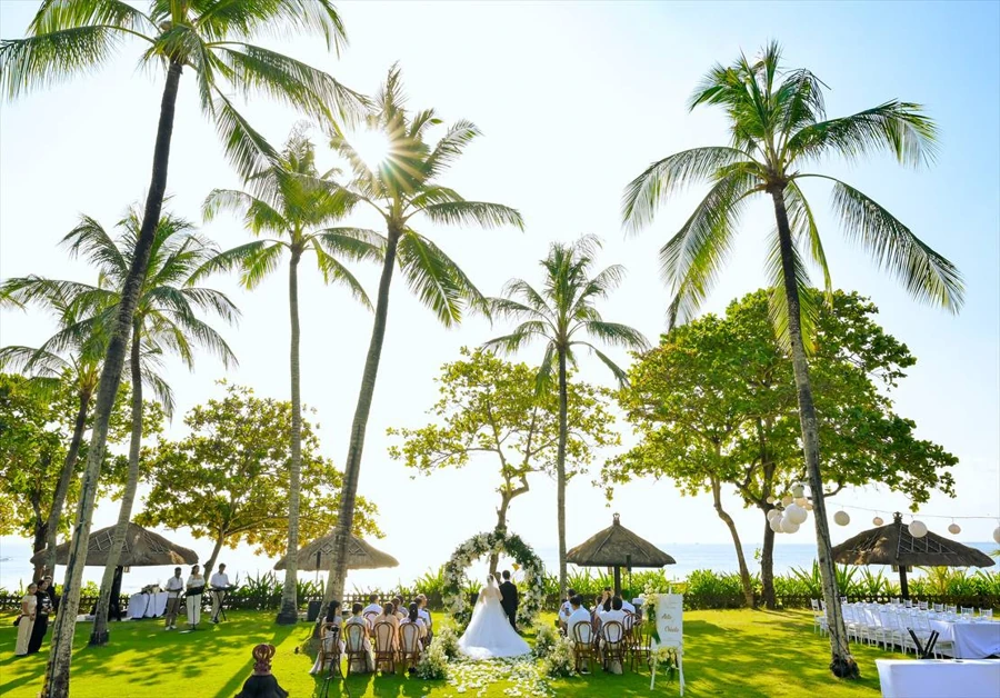 Tropical garden wedding ceremony beneath palm trees in Bali