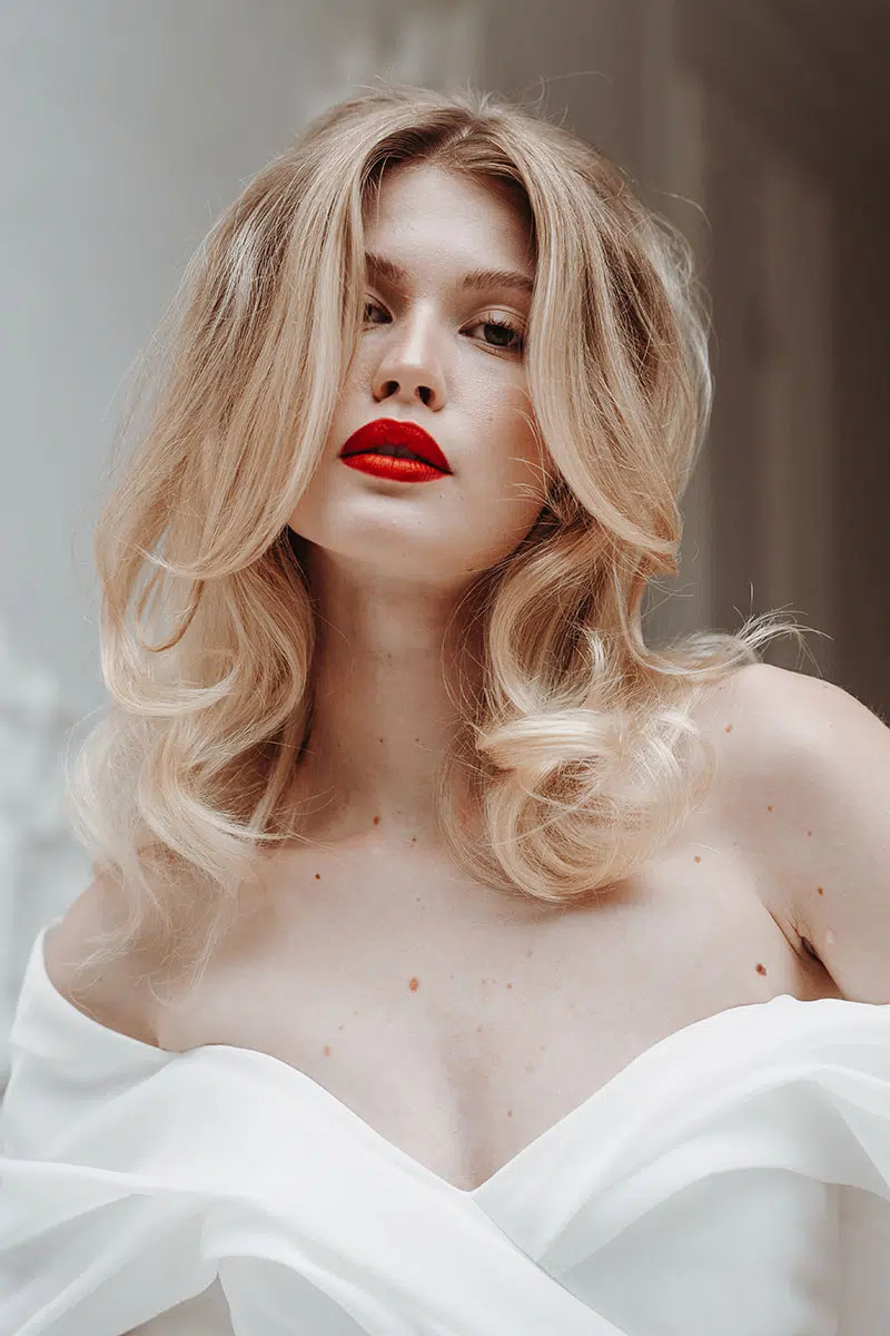 Bride wearing a vivid red statement lip with softly finished skin