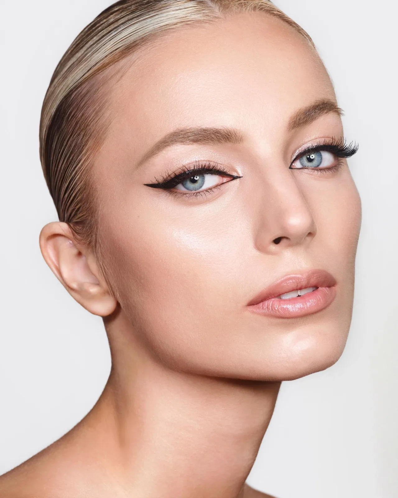 Editorial bridal makeup with precise black liner and a polished nude lip