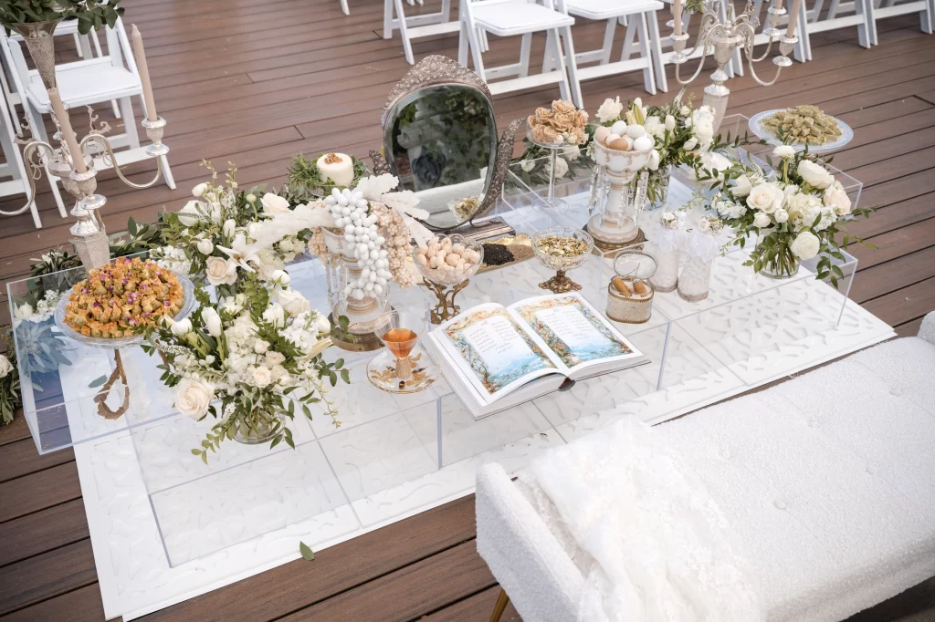 Elegant white and gold Sofreh Aghd with mirror, candles, flowers and traditional elements
