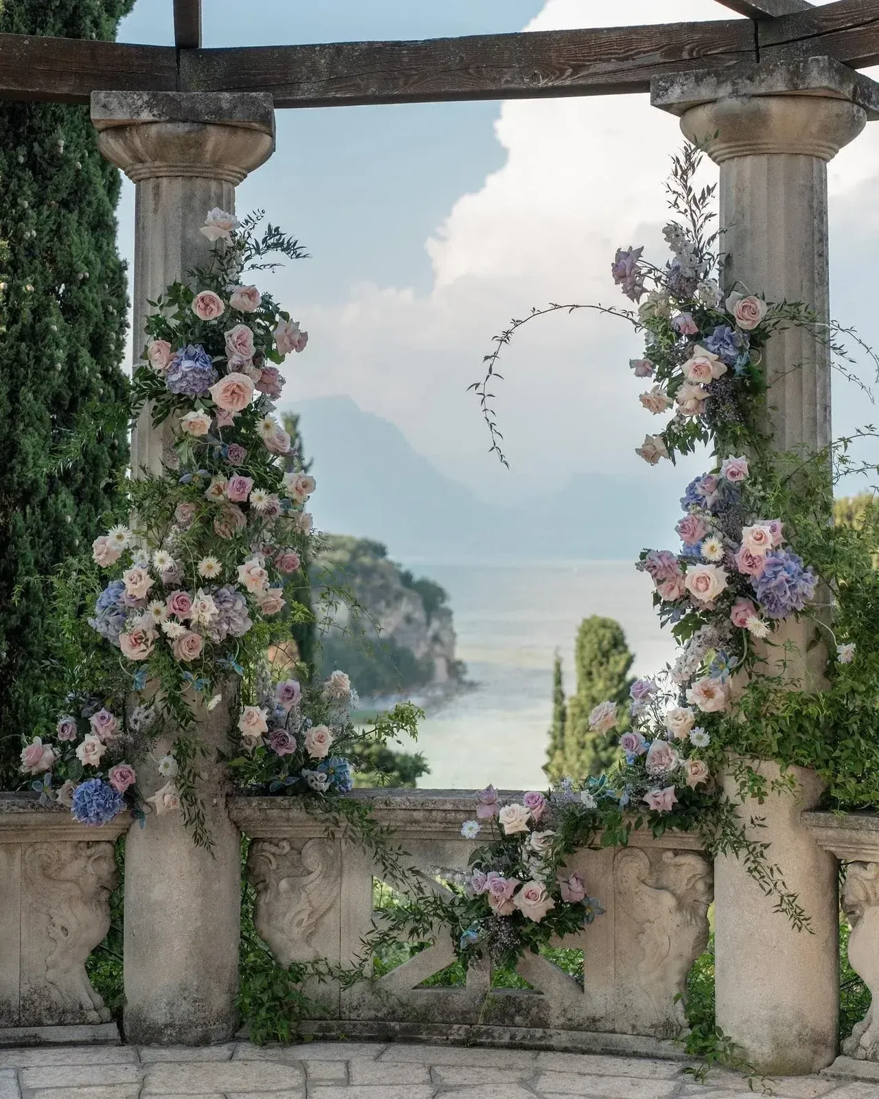 Pastel floral ceremony installation on a stone villa terrace