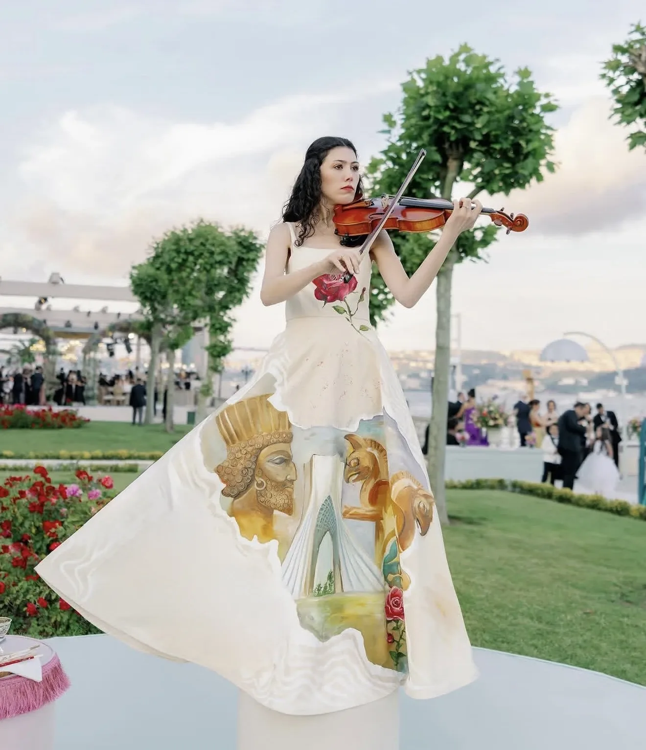 Full-length view of violinists performing outdoors in elegant gowns